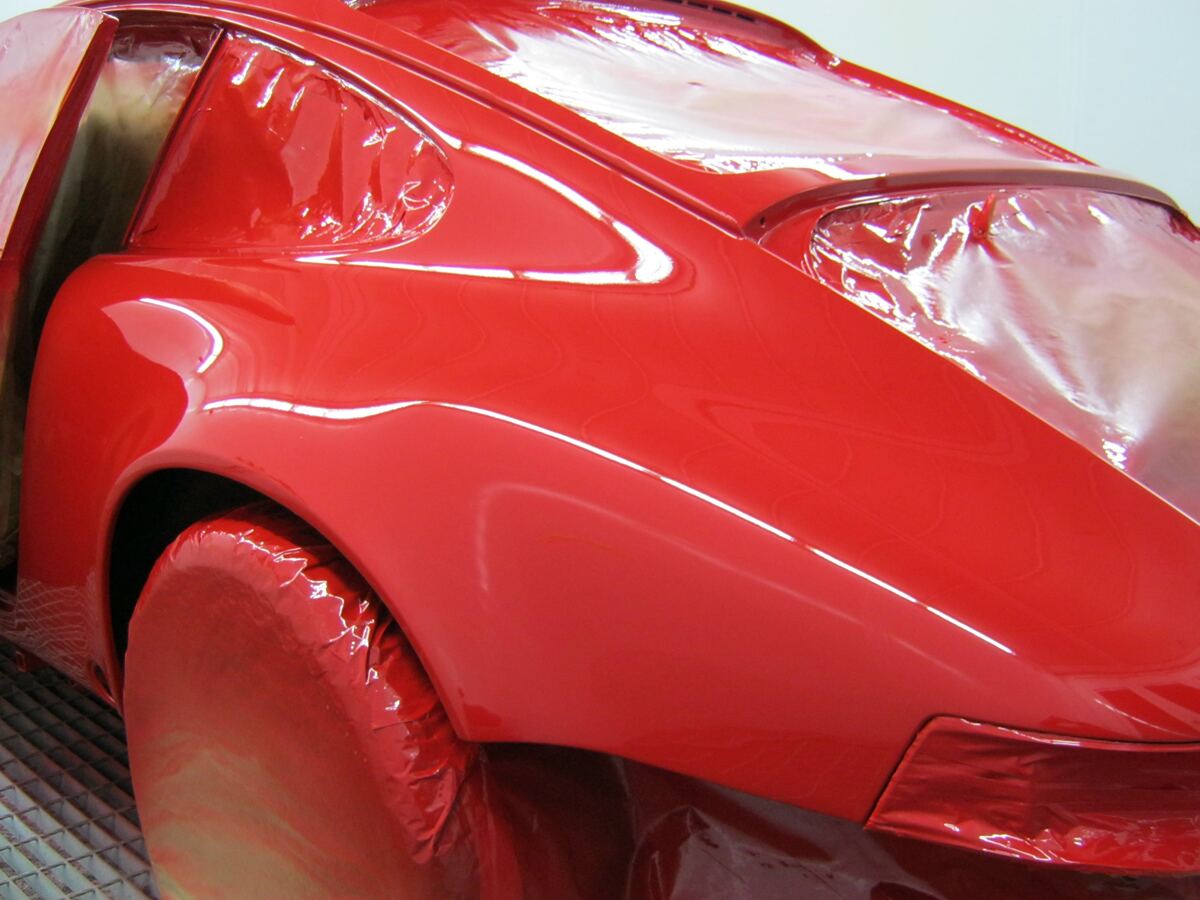 Freshly painted red bodywork in a spray booth